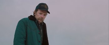 Movie still from “The Sweet Hereafter” (1997), directed by Atom Egoyan – A man with a beard wearing a hat and a jacket; Medium shot, Low angle