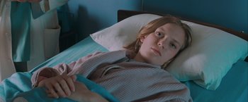 Movie still from “The Sweet Hereafter” (1997), directed by Atom Egoyan – A woman laying in a hospital bed looking sad; Close Up shot, High angle