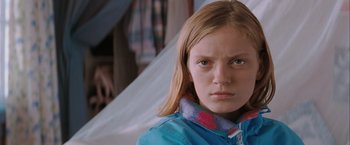 Movie still from “The Sweet Hereafter” (1997), directed by Atom Egoyan – A young girl wearing a blue shirt and a red and white scarf; Close Up shot, Low angle