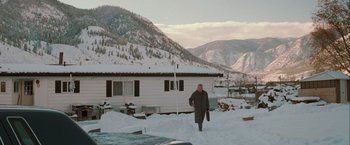 Movie still from “The Sweet Hereafter” (1997), directed by Atom Egoyan – A man walking in the snow in front of a house; Extreme Wide shot, High angle