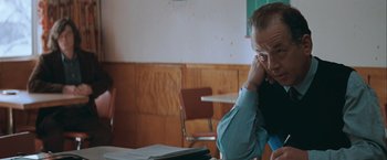Movie still from “The Sweet Hereafter” (1997), directed by Atom Egoyan – A man sitting at a table with papers in front of him; Close Up shot, Over the shoulder angle