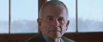 Movie still from “The Sweet Hereafter” (1997), directed by Atom Egoyan – An older man wearing a suit and tie; Close Up shot, Low angle