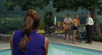 Movie still from “The Swimmer” (1968), directed by Sydney Pollack – A group of people standing around a swimming pool; Wide shot, Over the shoulder angle