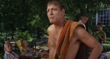 Movie still from “The Swimmer” (1968), directed by Sydney Pollack – A man with a towel around his neck; Medium shot, Low angle