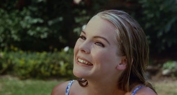 Movie still from “The Swimmer” (1968), directed by Sydney Pollack – A beautiful young lady sitting in the grass; Close Up shot, Over the shoulder angle
