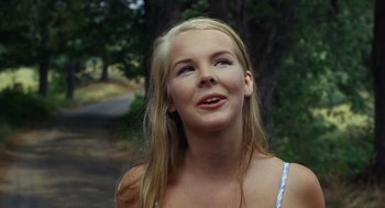 Movie still from “The Swimmer” (1968), directed by Sydney Pollack – A young blonde haired woman looking up into the sky; Close Up shot, Low angle