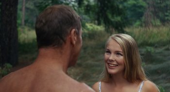 Movie still from “The Swimmer” (1968), directed by Sydney Pollack – A man and a woman are smiling at each other; Close Up shot, Over the shoulder angle
