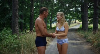 Movie still from “The Swimmer” (1968), directed by Sydney Pollack – A man and a woman shaking hands on the side of the road; Medium shot, Over the shoulder angle