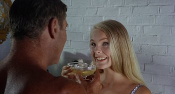 Movie still from “The Swimmer” (1968), directed by Sydney Pollack – A man and a woman holding a glass of wine; Close Up shot, Over the shoulder angle
