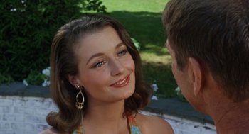 Movie still from “The Swimmer” (1968), directed by Sydney Pollack – A young woman smiles at a man in a park; Close Up shot, Over the shoulder angle