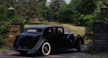 Movie still from “The Swimmer” (1968), directed by Sydney Pollack – An old car is parked on the side of the road; Wide shot, High angle