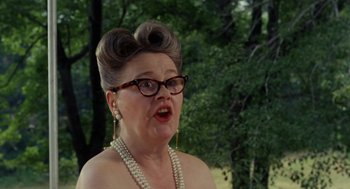 Movie still from “The Swimmer” (1968), directed by Sydney Pollack – An older woman wearing glasses and a pearl necklace; Close Up shot, Low angle