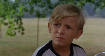 Movie still from “The Swimmer” (1968), directed by Sydney Pollack – A young blond boy with blue eyes stares into the distance; Close Up shot, High angle