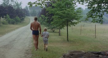 Movie still from “The Swimmer” (1968), directed by Sydney Pollack – A man and a boy walking down a dirt road; Wide shot, High angle