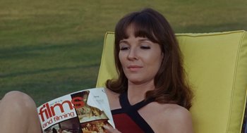 Movie still from “The Swimmer” (1968), directed by Sydney Pollack – A woman sitting in a lawn chair holding a magazine; Close Up shot, High angle