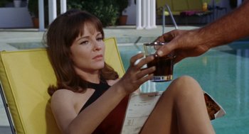 Movie still from “The Swimmer” (1968), directed by Sydney Pollack – A woman sitting next to a swimming pool holding a drink; Close Up shot, High angle