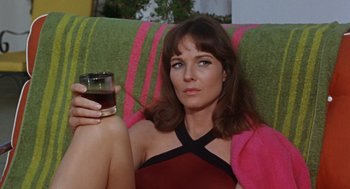 Movie still from “The Swimmer” (1968), directed by Sydney Pollack – A woman sitting on a couch holding a glass of wine; Close Up shot, High angle