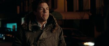 Movie still from “The Switch” (2010), directed by Josh Gordon – A man wearing a parka standing in a room; Close Up shot, Over the shoulder angle