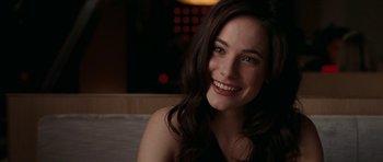 Movie still from “The Switch” (2010), directed by Josh Gordon – A woman with long dark brown hair smiles for the camera; Close Up shot, Over the shoulder angle