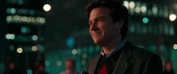 Movie still from “The Switch” (2010), directed by Josh Gordon – A person wearing a suit and smiling; Close Up shot, Over the shoulder angle