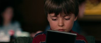 Movie still from “The Switch” (2010), directed by Josh Gordon – A young boy is looking at a laptop; Close Up shot, High angle