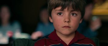 Movie still from “The Switch” (2010), directed by Josh Gordon – A young boy's face looking at the camera; Close Up shot, Over the shoulder angle