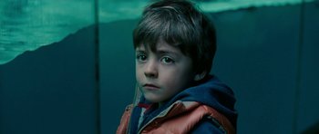 Movie still from “The Switch” (2010), directed by Josh Gordon – A young boy in a red and blue jacket; Close Up shot, Over the shoulder angle
