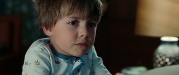 Movie still from “The Switch” (2010), directed by Josh Gordon – A young boy wearing pajamas looking at the camera; Close Up shot, High angle