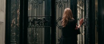Movie still from “The Switch” (2010), directed by Josh Gordon – A woman standing in front of an iron gate; Medium shot, Over the shoulder angle