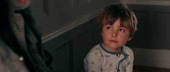 Movie still from “The Switch” (2010), directed by Josh Gordon – A little boy wearing pajamas sitting in a room; Close Up shot, Over the shoulder angle