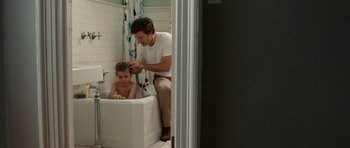 Movie still from “The Switch” (2010), directed by Josh Gordon – A man and a child in a bath tub; Wide shot, Over the shoulder angle