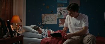 Movie still from “The Switch” (2010), directed by Josh Gordon – A man sitting next to a child in a bed; Medium shot, High angle