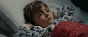 Movie still from “The Switch” (2010), directed by Josh Gordon – A young boy laying in bed with his head resting on a pillow; Close Up shot, High angle