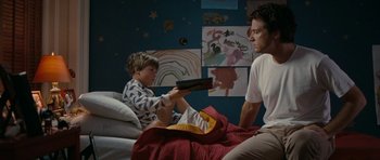 Movie still from “The Switch” (2010), directed by Josh Gordon – A man and a boy sitting on a bed; Medium shot, Low angle