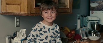 Movie still from “The Switch” (2010), directed by Josh Gordon – A young boy wearing a white shirt with blue leaves on it; Close Up shot, Over the shoulder angle