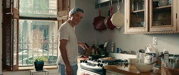 Movie still from “The Switch” (2010), directed by Josh Gordon – A man standing in front of an oven in a kitchen; Medium shot, Low angle