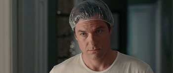 Movie still from “The Switch” (2010), directed by Josh Gordon – A person wearing a plastic hat; Close Up shot, Over the shoulder angle