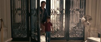 Movie still from “The Switch” (2010), directed by Josh Gordon – A man and a boy standing in front of an open door; Medium shot, Over the shoulder angle