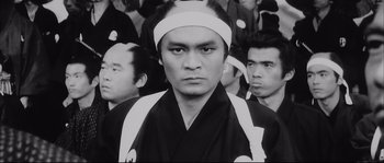 Movie still from “The Sword of Doom” (1966), directed by Kihachi Okamoto – Black and white photograph of a man in a crowd; Close Up shot, Low angle