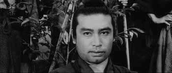 Movie still from “The Sword of Doom” (1966), directed by Kihachi Okamoto – Black and white photograph of a man in a suit; Close Up shot, Low angle