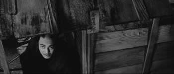 Movie still from “The Sword of Doom” (1966), directed by Kihachi Okamoto – A man standing in front of a wooden wall; Medium shot, Low angle