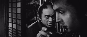 Movie still from “The Sword of Doom” (1966), directed by Kihachi Okamoto – A man is looking at another man's reflection in a mirror; Close Up shot, Over the shoulder angle