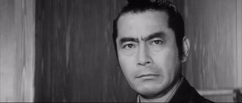 Movie still from “The Sword of Doom” (1966), directed by Kihachi Okamoto – Black and white photograph of a man's face in front of a wooden wall; Close Up shot, Low angle