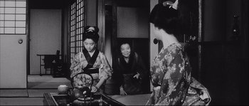 Movie still from “The Sword of Doom” (1966), directed by Kihachi Okamoto – Two geishas in traditional clothing are looking in the mirror; Medium shot, Low angle