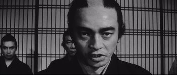 Movie still from “The Sword of Doom” (1966), directed by Kihachi Okamoto – A man in a black robe and a man in a black robe; Close Up shot, Low angle