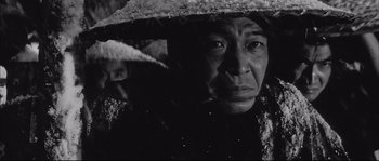 Movie still from “The Sword of Doom” (1966), directed by Kihachi Okamoto – An older man wearing a straw hat and looking at the camera; Close Up shot, Low angle
