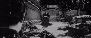 Movie still from “The Sword of Doom” (1966), directed by Kihachi Okamoto – A man sitting on the ground next to dead bodies; Wide shot, High angle