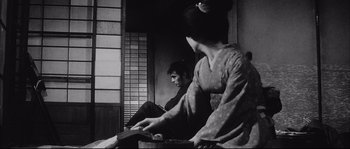 Movie still from “The Sword of Doom” (1966), directed by Kihachi Okamoto – A man and a woman sitting on a bench; Medium shot, Low angle