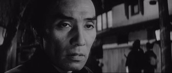 Movie still from “The Sword of Doom” (1966), directed by Kihachi Okamoto – A black - and - white photo of a man's face; Close Up shot, Low angle