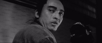 Movie still from “The Sword of Doom” (1966), directed by Kihachi Okamoto – A black and white photo of a man with a sad look on his face; Close Up shot, Low angle